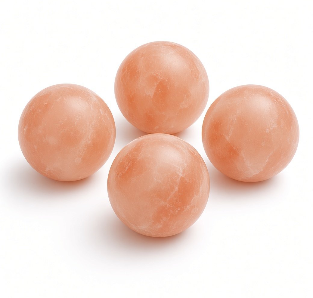 Polished Himalayan pink salt balls in multiple sizes on white background